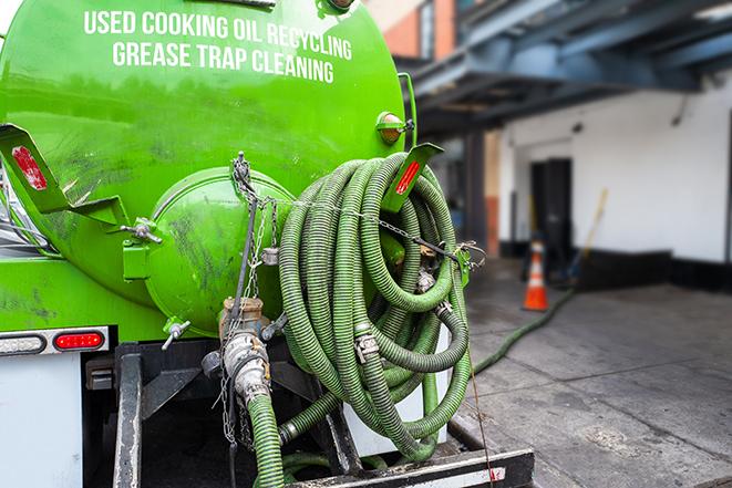 grease trap being pumped out by service technician in Hamilton